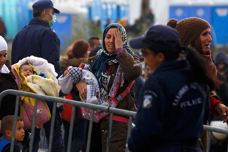 Người phụ nữ ôm con nhỏ tại biên giới Hy Lạp-Macedonia. (Ảnh: Reuters)