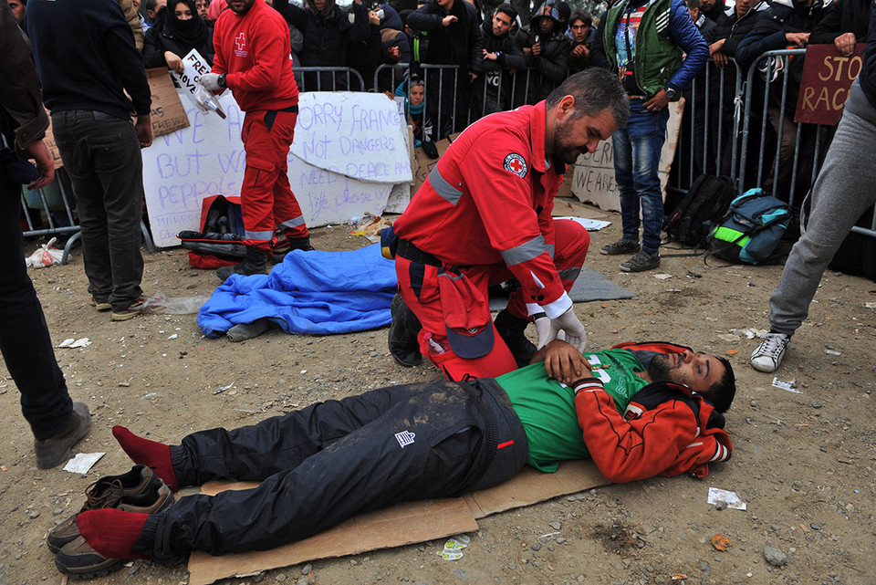 Nhân viên Chữ thập Đỏ hỗ trợ người tị nạn bị kiệt sức. (Ảnh: AFP)