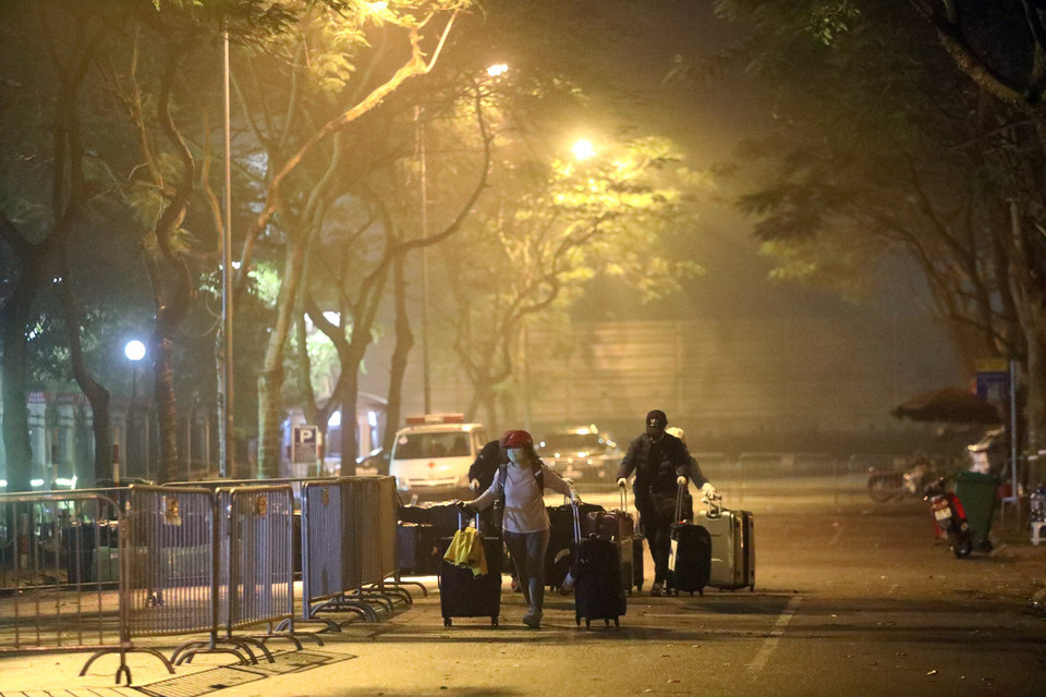 Các du học sinh đang vận chuyển đồ đạc về khu nhà ở cách ly tập trung. (Ảnh: Huy Hùng/TTXVN)