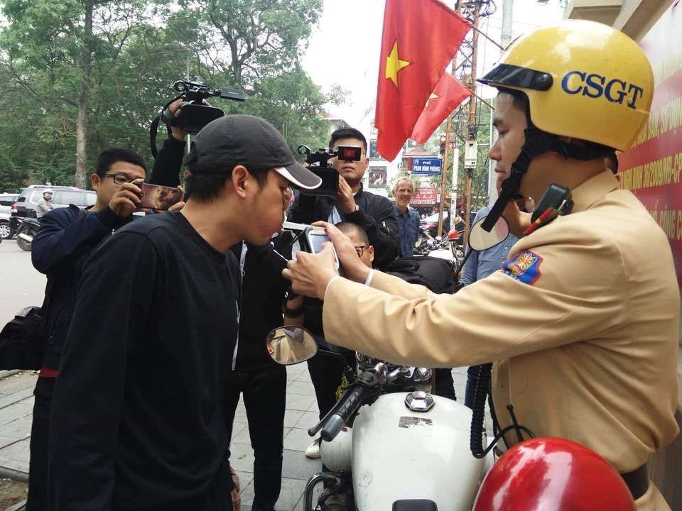 Lực lượng chức năng tiến hành đo nồng độ cồn đối với người điều khiển xe máy vi phạm tại nút giao thông Hàng Cót-Phan Đình Phùng. (Ảnh: TTXVN phát)