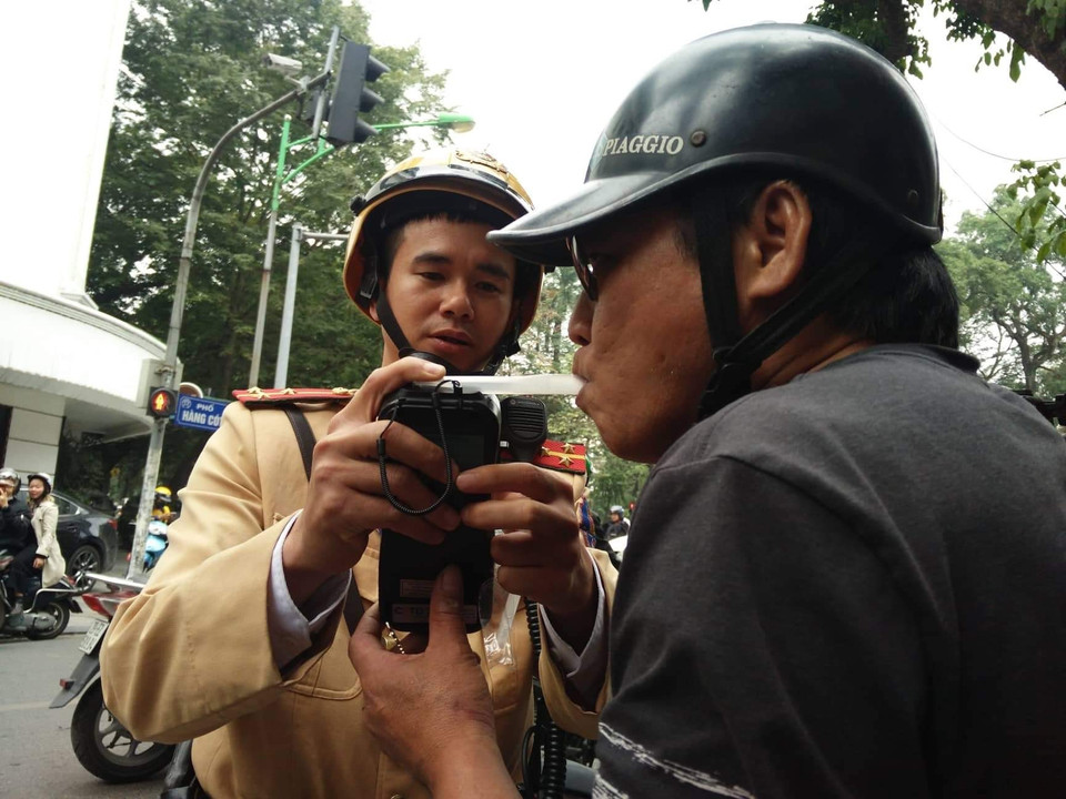Lực lượng chức năng tiến hành đo nồng độ cồn đối với người điều khiển xe máy vi phạm tại nút giao thông Hàng Cót-Phan Đình Phùng. (Ảnh: TTXVN phát)