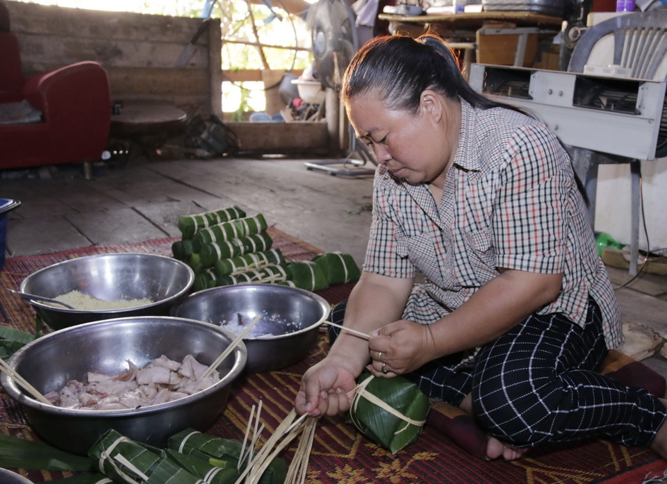 Chị Nguyễn Thị Hà gói bánh để dâng Bác. (Ảnh: Phạm Kiên/Vietnam+)