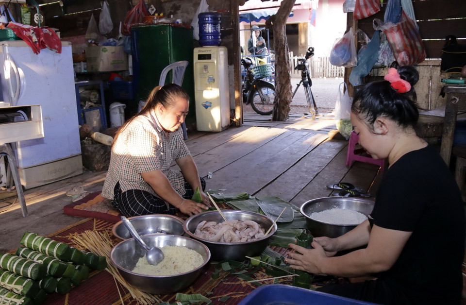 Chị Nguyễn Thị Hà và các thành viên trong gia đình gói bánh để dâng Bác. (Ảnh: Phạm Kiên/Vietnam+)