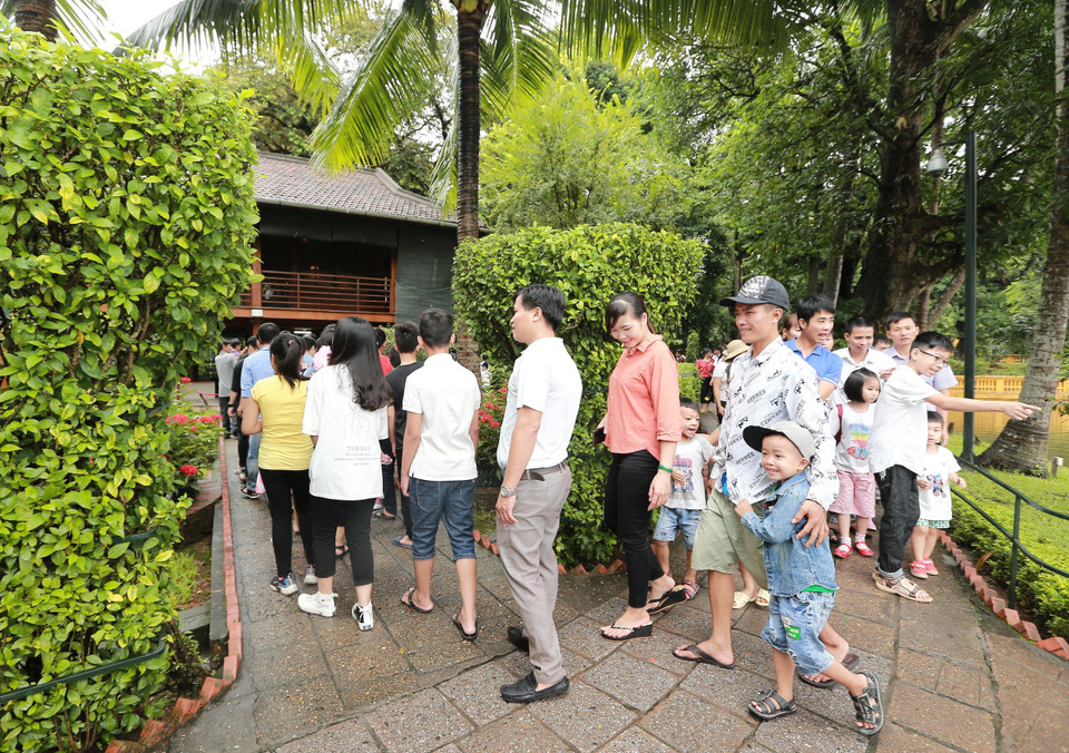 Người dân, du khách đến tham quan Nhà sàn Bác Hồ trong khuôn viên Khu Di tích Chủ tịch Hồ Chí Minh. (Ảnh: Lâm Khánh/TTXVN)
