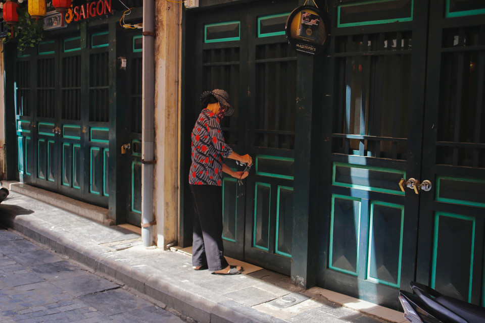 Cô Bích Hạnh (chủ một quán bia ở phố Tạ Hiện) cho biết: “Từ khi có yêu cầu tạm dừng hoạt động thì tuần này cô đã đóng cửa quán. Duy chỉ có buổi sáng là cô đến dọn dẹp vệ sinh, khử khuẩn. Giờ cô chỉ mong sao dịch bệnh mau chóng qua đi cho nhà nước và đội ngũ y bác sỹ, bộ đội biên phòng... đỡ vất vả, nhân dân cũng được yên tâm mà sinh sống và làm ăn”. (Ảnh: Thế Mạnh/Vietnam+)