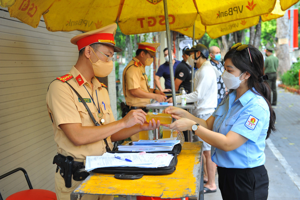  Các cô giáo là Tổng phụ trách Đội của Thủ đô trao tặng đồ uống cho lực lượng công an Thủ đô đang thực hiện nhiệm vụ tại 6 tổ tuần tra kiểm soát lưu động trên các tuyến đường. (Ảnh: Minh Đức/TTXVN)