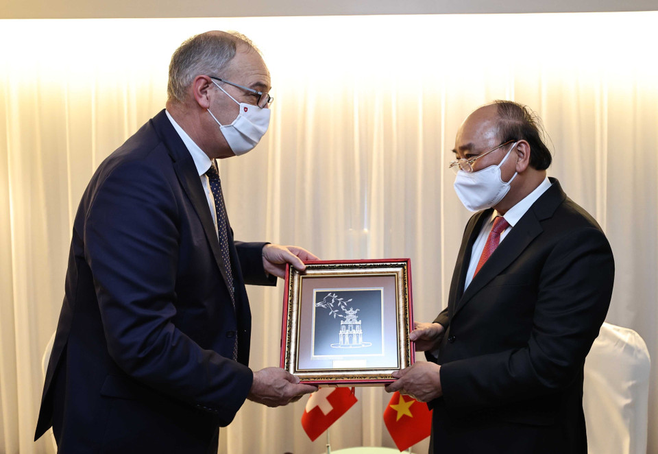 Chủ tịch nước Nguyễn Xuân Phúc tặng Tổng thống Thụy Sĩ Guy Parmelin quà lưu niệm. (Ảnh: Thống Nhất/TTXVN)