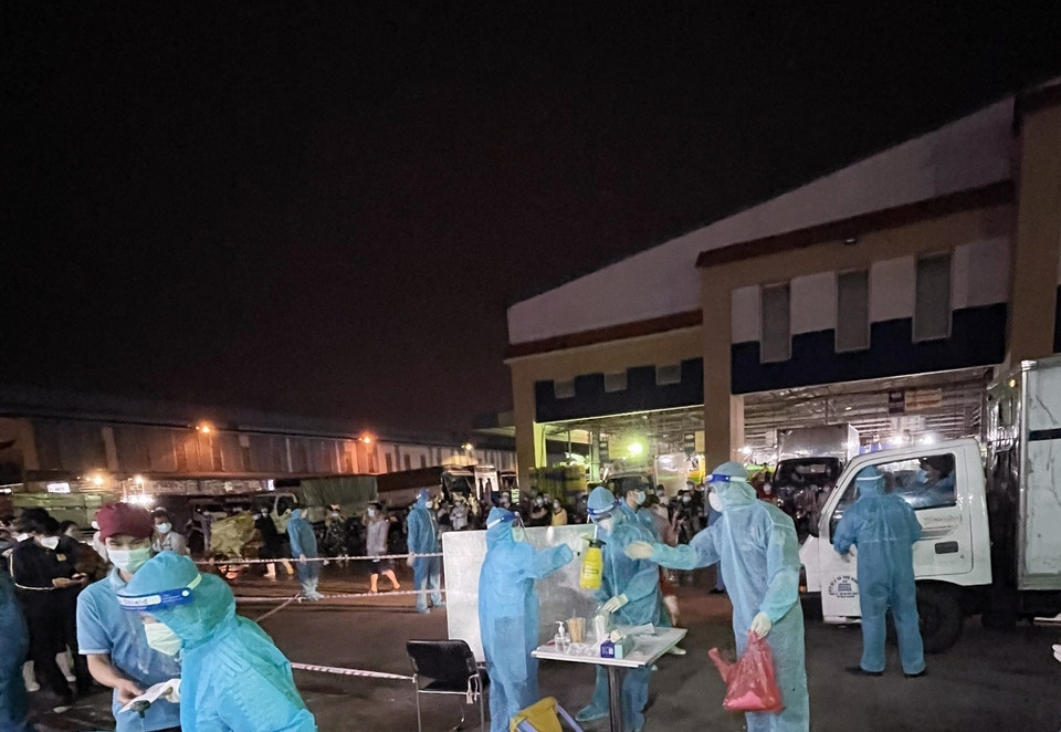 Lực lượng chức năng lấy mẫu tầm soát dịch COVID-19 tại chợ đầu mối nông sản thực phẩm Bình Điền. (Ảnh: TTXVN)