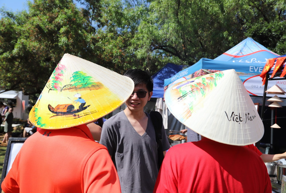 Rất nhiều khách bày tỏ sự quan tâm và yêu thích đối với nón lá Việt Nam. (Ảnh: Hồng Minh/TTXVN)