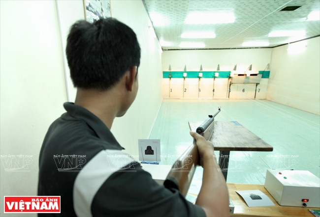 Một người tập bắn đang suy nghĩ điều chỉnh cách ngắm bắn của mình.