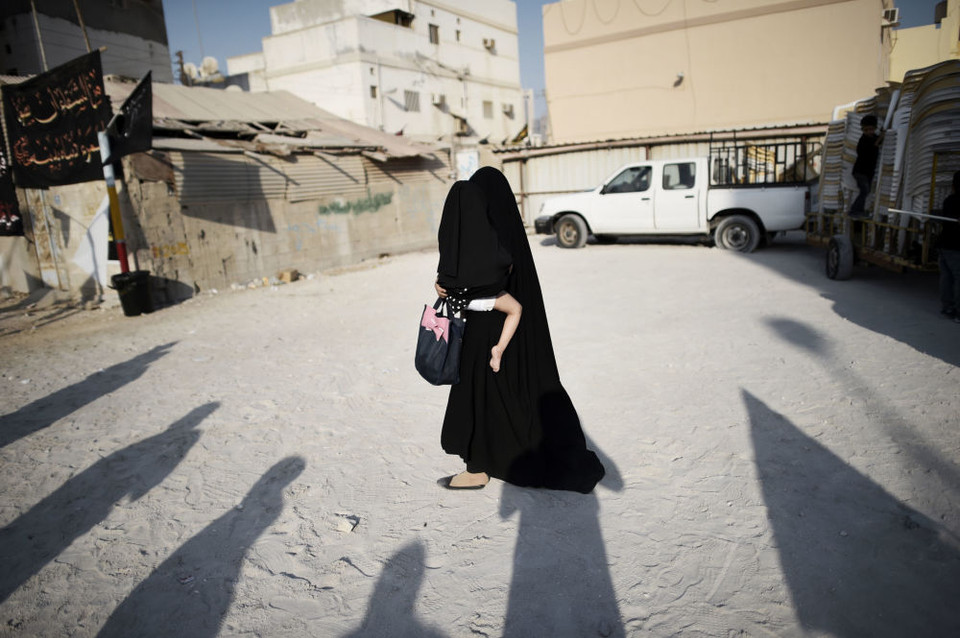 Người phụ nữ Hồi giáo dòng Shiite bế con trong buổi lễ Ashura kỷ niệm ngày mất của cháu trai nhà tiên tri Mohammed tại Đông Manama. (Ảnh: AFP)