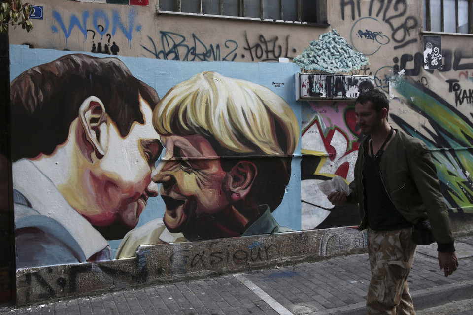 Bức tranh graffiti vẽ Thủ tướng Hy Lạp Alexis Tsipras và Thủ tướng Đức Angela Merkel tại Athens. (Ảnh: AP)