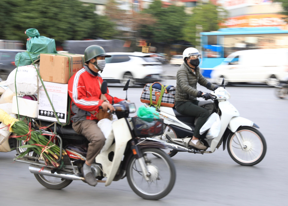 Dễ dàng bắt gặp trên tuyến đường tại cửa ngõ Thủ đô hình ảnh người dân chằng, buộc đồ đạc… rời Hà Nội. (Ảnh: Hoàng Hiếu/TTXVN)