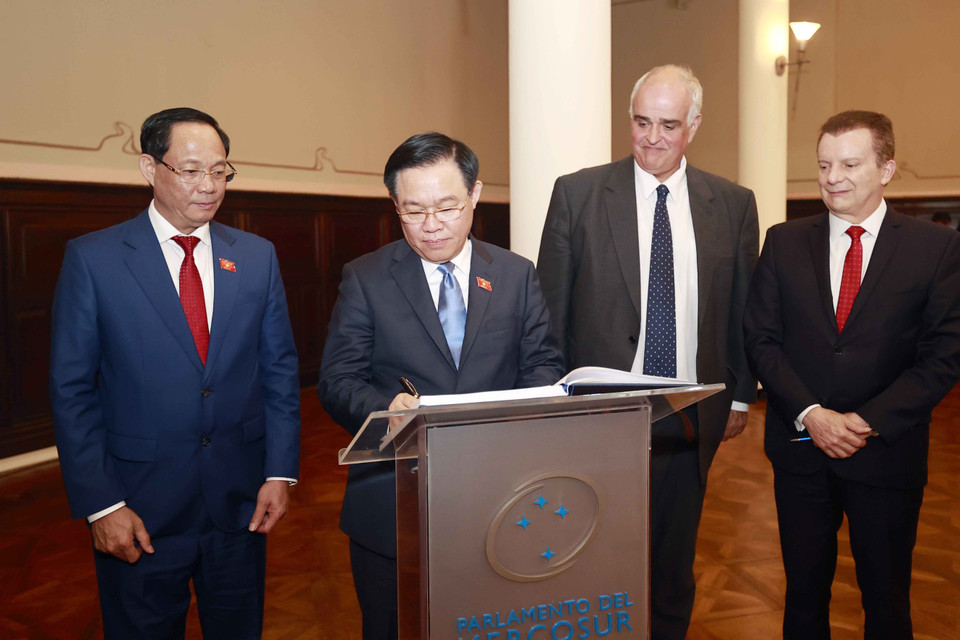 Chủ tịch Quốc hội Vương Đình Huệ ký sổ lưu niệm. (Ảnh: Doãn Tấn/TTXVN)