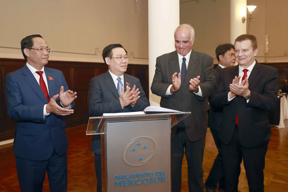 Chủ tịch Quốc hội Vương Đình Huệ ký sổ lưu niệm. (Ảnh: Doãn Tấn/TTXVN)