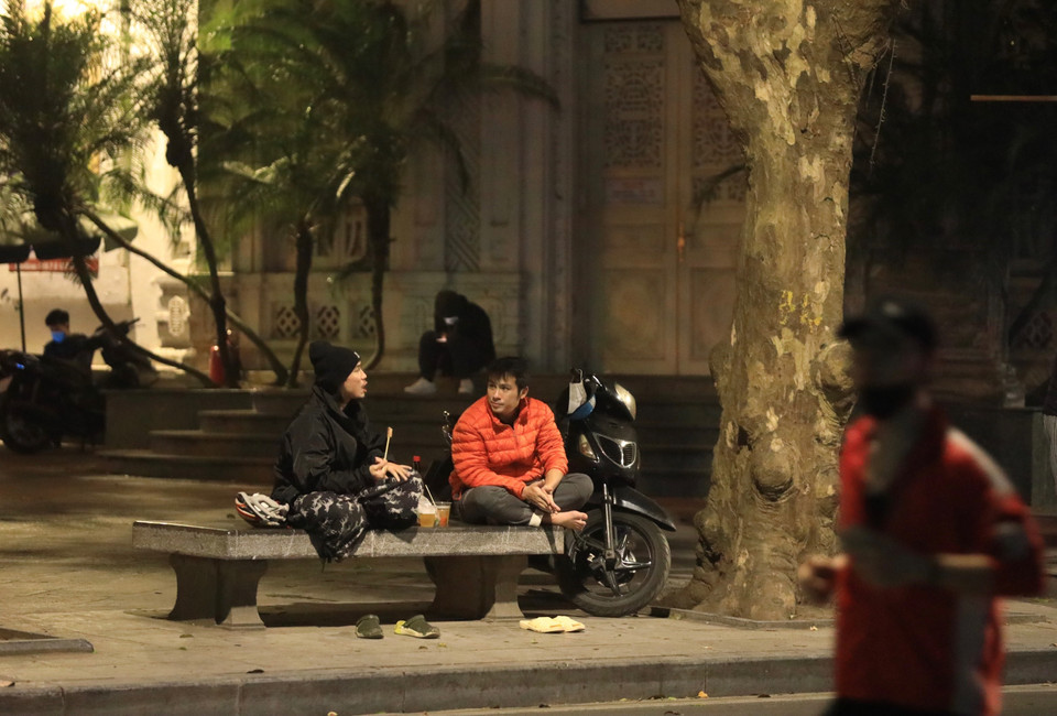 Một số người dân vẫn còn chủ quan trong phòng dịch tại khu vực công cộng (ảnh chụp tại phố Lê Thái Tổ tối 16/1). (Ảnh: Hoàng Hiếu/TTXVN)