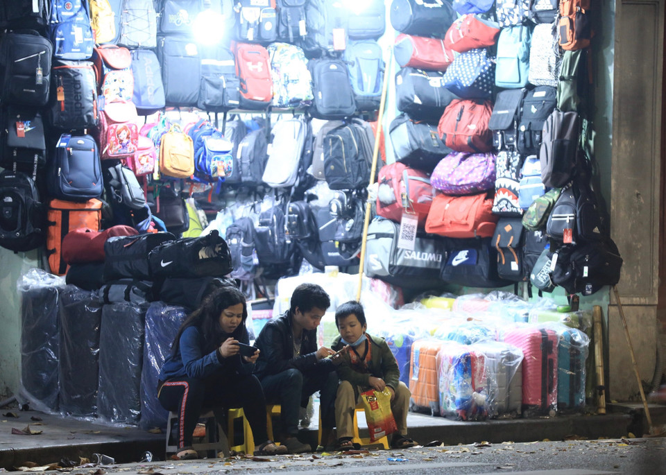 Một số người bán hàng trên phố Đinh Tiên Hoàng vẫn còn chủ quan không đeo khẩu trang hoặc đeo không đúng cách. (Ảnh: Hoàng Hiếu/TTXVN)