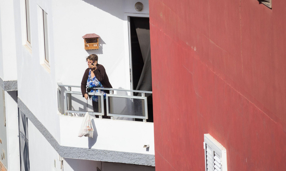 Một người phụ nữ ở Las Palmas, Gran Canaria kéo giỏ thực phẩm từ ban công do người hàng xóm mua hộ. (Ảnh: Alamy Live News)