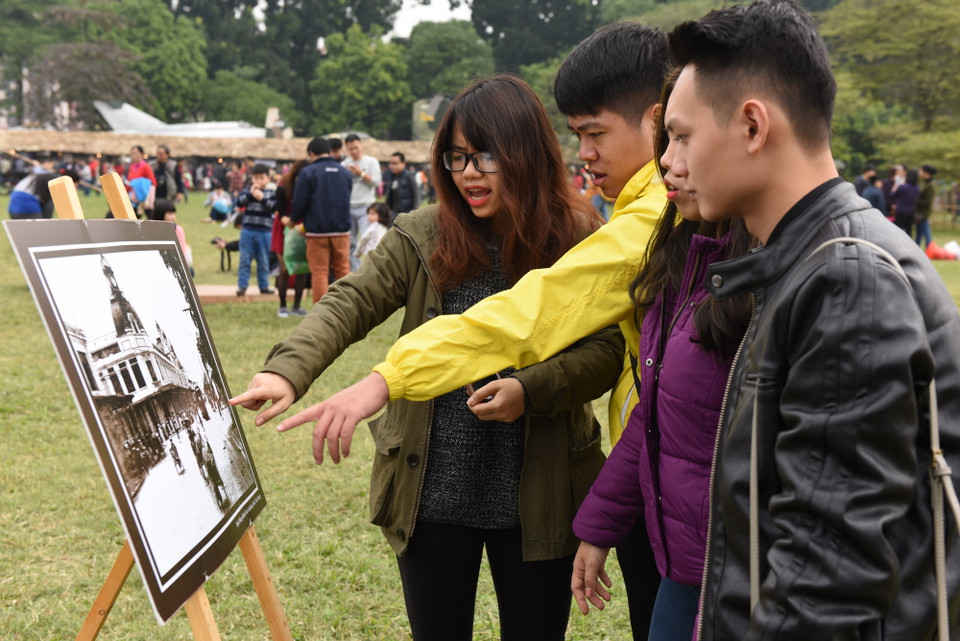 Du khách ngắm nhìn những bức ảnh về Hà Nội xưa. (Ảnh: Nguyễn Văn Cảnh/TTXVN)