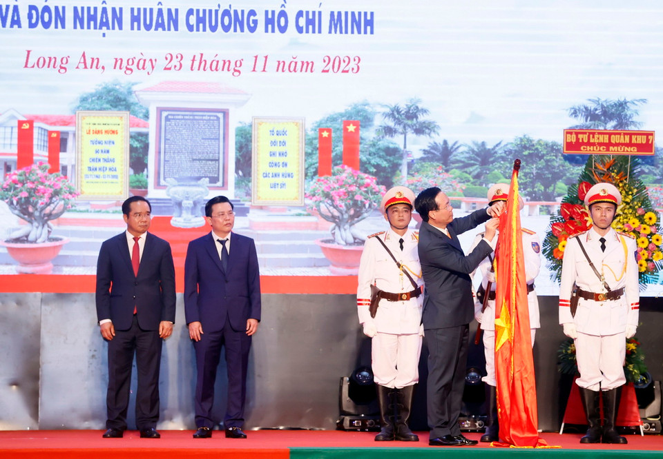 Chủ tịch nước Võ Văn Thưởng gắn Huân chương Hồ Chí Minh lên cờ truyền thống của tỉnh Long An. (Ảnh: Thống Nhất/TTXVN)