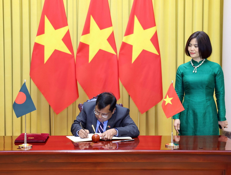 Đại sứ Bangladesh Mohammad Lutfor Rahman viết lưu bút. (Ảnh: Thống Nhất/TTXVN)