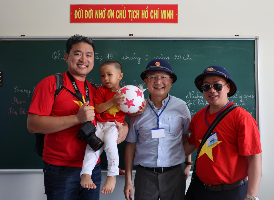 Các kiều bào tặng quà cho học sinh trường Tiểu học xã Song Tử Tây, huyện đảo Trường Sa, tỉnh Khánh Hòa. (Ảnh: Diệp Trương/TTXVN)