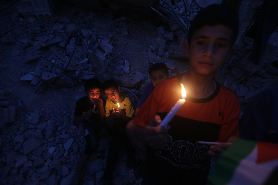 Trẻ em Palestine sinh hoạt trong điều kiện không có điện bên những ngôi nhà đổ nát sau các cuộc không kích của Israel xuống thành phố Rafah ở Dải Gaza, ngày 25/5/2021. (Ảnh: THX/TTXVN)