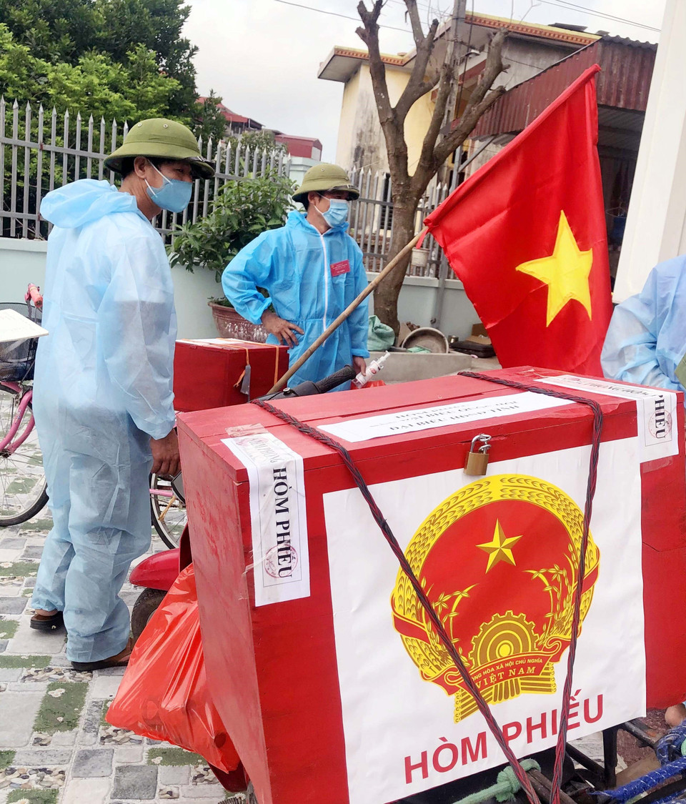 Tổ công tác đặc biệt chở hòm phiếu di động đến từng hộ gia đình trong khu cách ly xã hội xã Đạo Lý, huyện Lý Nhân, Hà Nam. (Ảnh: Đại Nghĩa/TTXVN)