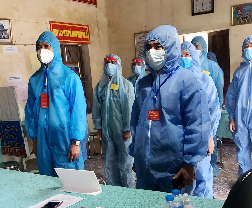 Các đại biểu làm lễ chào cờ trong trang phục phòng chống dịch tại khu cách ly xã hội xã Đạo Lý, huyện Lý Nhân, Hà Nam. (Ảnh: Đại Nghĩa/TTXVN)