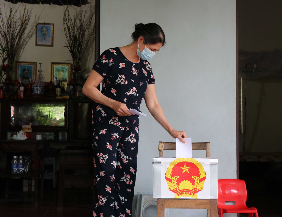 Cử tri đang cách ly tại nhà bầu cử bằng hòm phiếu phụ. (Ảnh: Thanh Thương/TTXVN)