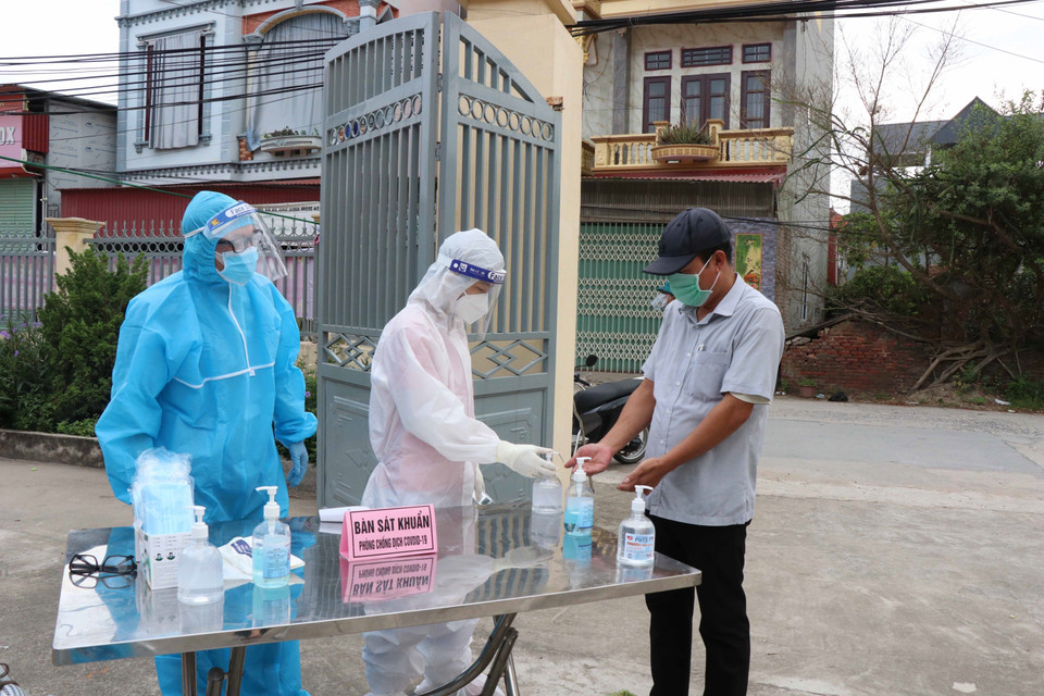 Kiểm tra thân nhiệt, sát khuẩn cho cử tri đến bầu cử tại Mão Điền. (Ảnh: Thanh Thương/TTXVN)