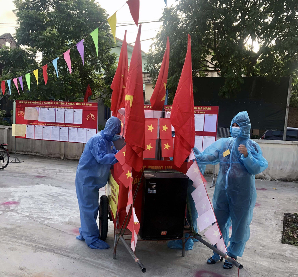 Tổ bầu cử di chuyển hòm phiếu đến các hộ dân đang thực hiện cách ly tại nhà để giúp họ thực hiện quyền bầu cử của mình. (Ảnh: Đại Nghĩa/TTXVN)