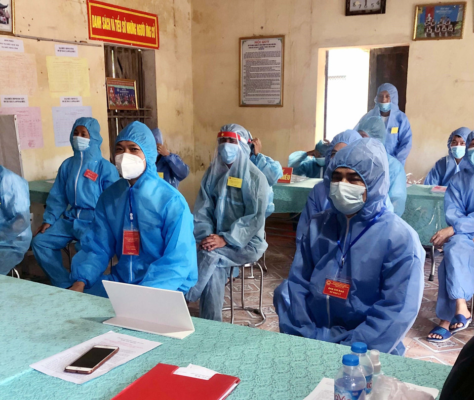 Các cử tri, tổ bầu cử thực hiện nghi thức chào cờ chưa từng có vì dịch COVID-19 tại thôn Quan Nhân, xã Đạo Lý, huyện Lý Nhân, Hà Nam. (Ảnh: Đại Nghĩa/TTXVN)