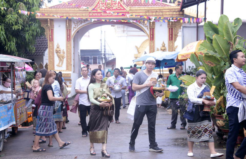 Đông đảo người dân thủ đô Vientiane trong những bộ trang phục truyền thống đẹp mắt đã đổ đến các chùa gần nhà để thực hiện nghi thức Tak Bath. (Ảnh: Phạm Kiên/Vietnam+)
