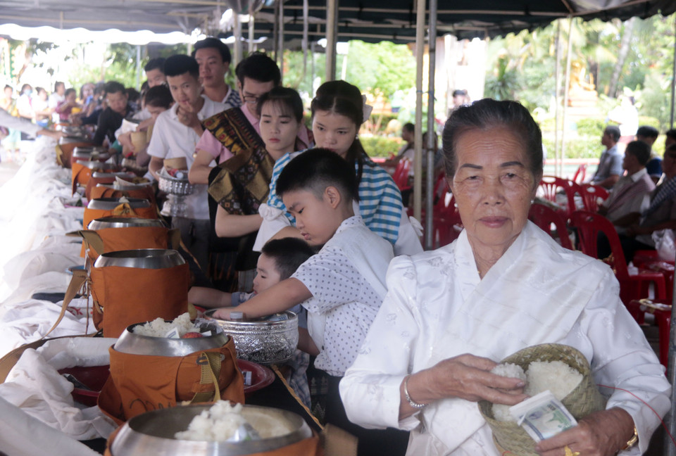 Người dân Vientiane dâng lễ cho các nhà sư và những người đã khuất. (Ảnh: Phạm Kiên/Vietnam+)
