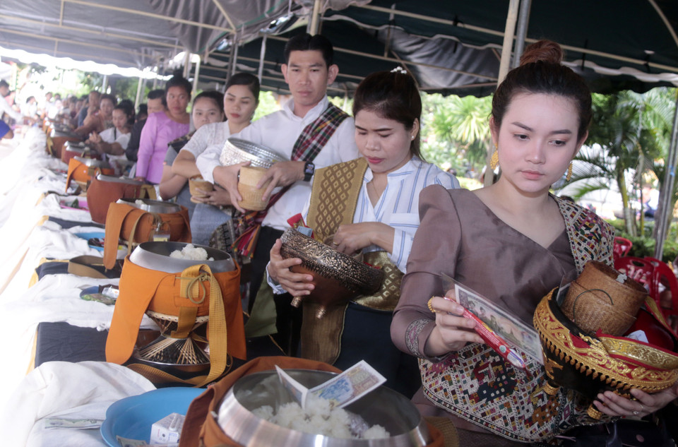 Do dịch bệnh đã được kiểm soát tương đối tốt, người dân Vientiane đủ mọi lứa tuổi đã đổ đến chùa vào sáng sớm để thực hiện nghi thức Tak Bath.(Ảnh: Phạm Kiên/Vietnam+)