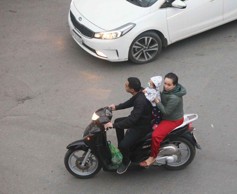 Nhiều người chở theo trẻ nhỏ nhưng vẫn không đội mũ bảo hiểm. (Ảnh: Thanh Tùng/TTXVN)
