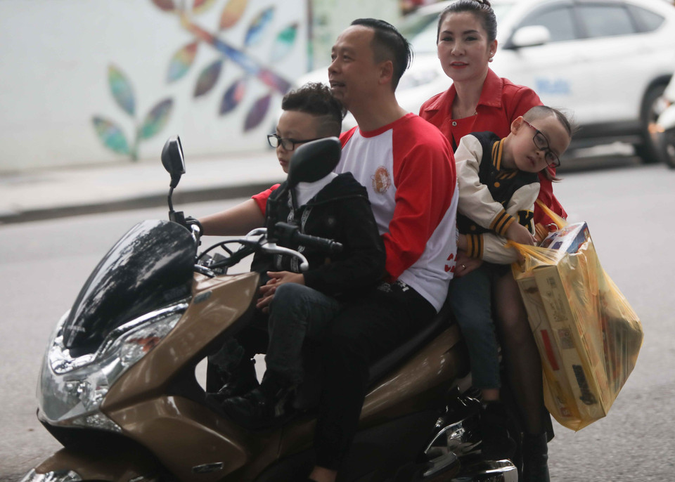 Nhiều người chở theo trẻ nhỏ nhưng vẫn không đội mũ bảo hiểm. (Ảnh: Thanh Tùng/TTXVN)