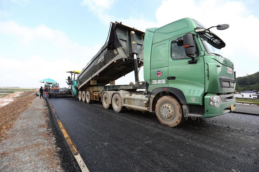 Công tác thảm nhựa bêtông đang được các nhà thầu tranh thủ thi công khi thời tiết thuận lợi. (Ảnh: Huy Hùng/TTXVN)