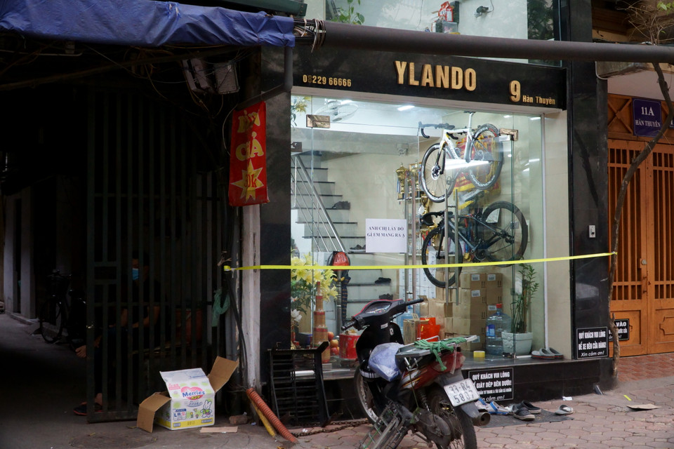 Một số cửa hàng còn hoạt động nhưng không cho khách vào trong mà sẽ mang hàng hóa ra tận nơi. (Ảnh: Vi Diệu/Vietnam+)