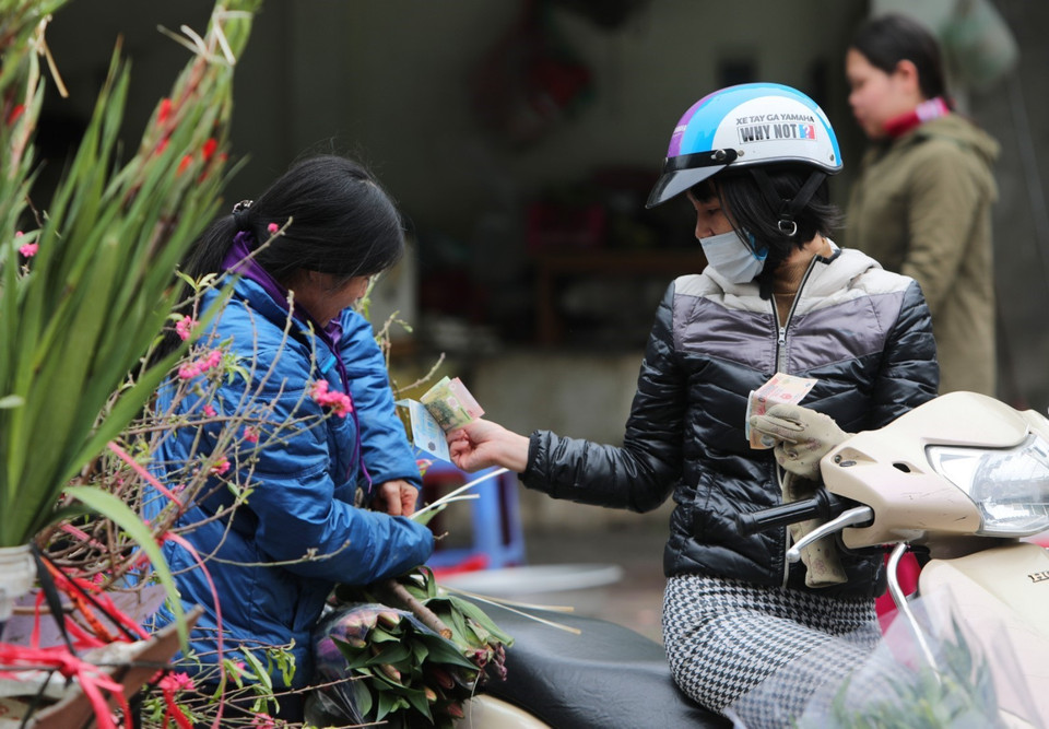 Người dân Thủ đô ra đường đi chợ vẫn đeo khẩu trang y tế. (Ảnh: Thành Đạt/TTXVN)