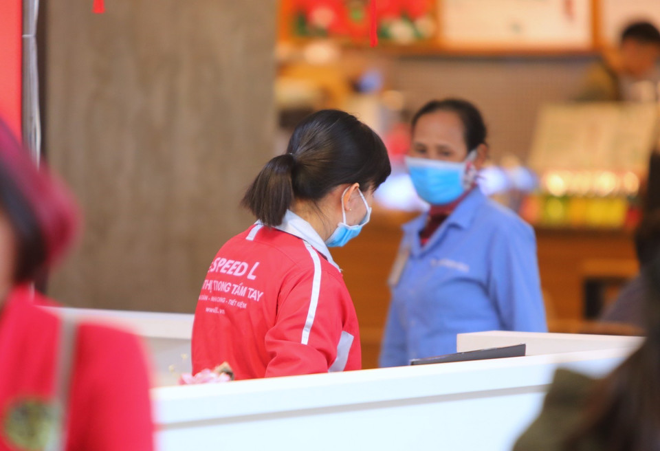 Các nhân viên bảo vệ, nhân viên bán hàng tại nhiều trung tâm thương mại được trang bị khẩu trang khi làm việc. (Ảnh: Thành Đạt/TTXVN)