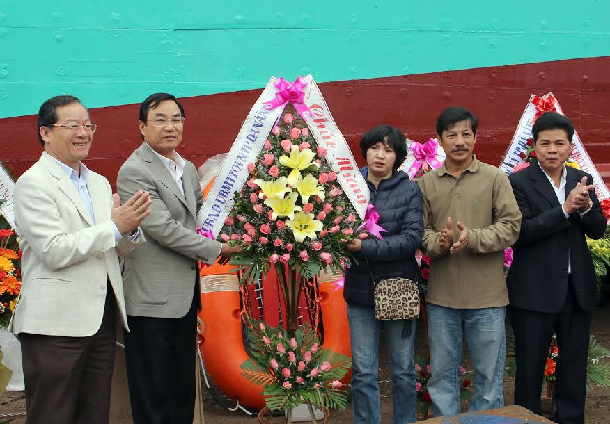 Lãnh đạo thành phố Đà Nẵng tặng hoa chúc mừng gia đình bà Như Hoa tại lễ hạ thủy tàu. (Ảnh: Trần Lê Lâm/Vietnam+)