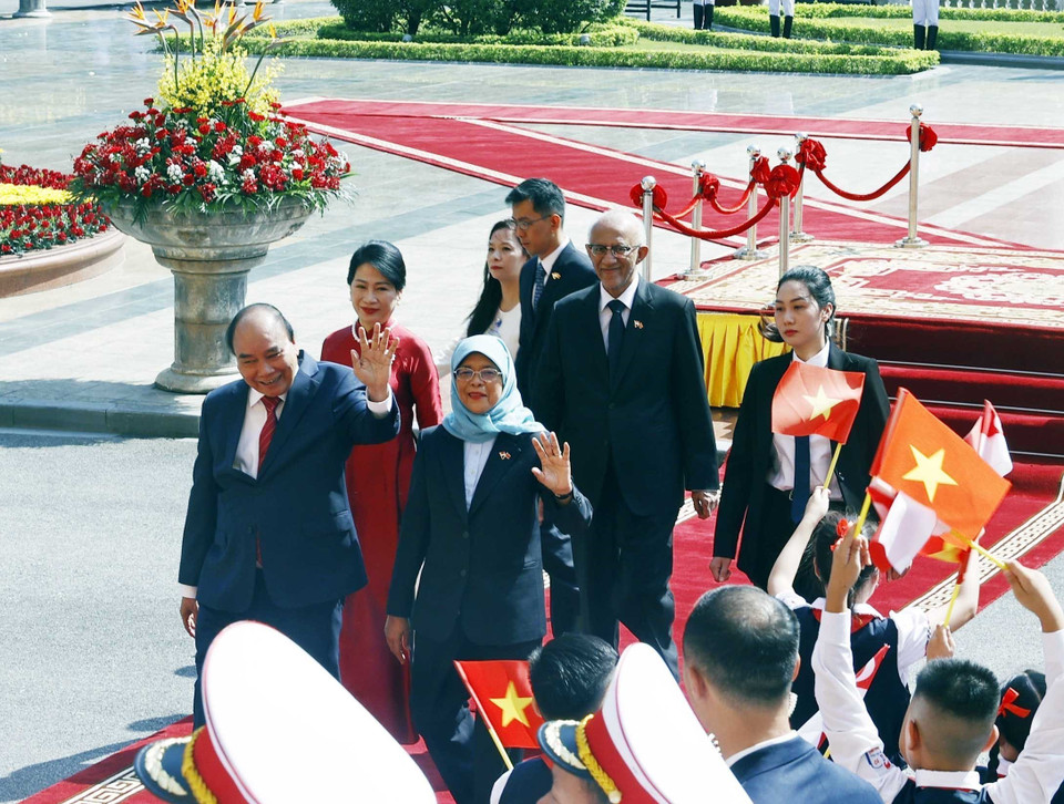 Chủ tịch nước Nguyễn Xuân Phúc và Phu nhân cùng Tổng thống Cộng hòa Singapore Halimah Yacob và Phu quân tại lễ đón. (Ảnh: Thống Nhất/TTXVN)