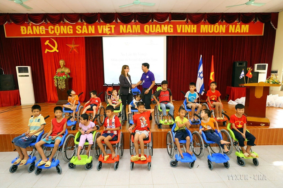 Đại sứ quán Israel phối hợp với Ủy ban Quốc gia về Người Khuyết tật Việt Nam tổ chức trao tặng xe lăn cho 20 trẻ em khuyết tật của 2 huyện Quốc Oai và Ứng Hòa (Hà Nội, 20/6/2017). (Ảnh: Anh Tuấn/TTXVN)