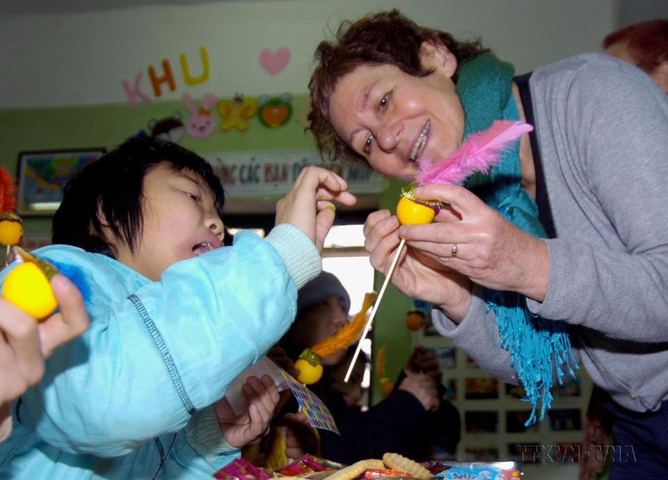 Nghệ sỹ Nhà hát rối TRAIN (Israel) hướng dẫn trẻ em bị nhiễm chất độc da cam tại Làng Hoà Bình (Thanh Xuân, Hà Nội) làm những con rối ngộ nghĩnh (18/2/2008). (Ảnh: Quốc Khánh/TTXVN)