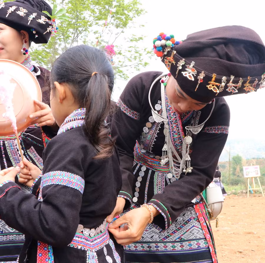 Một người mẹ sửa lại trang phục cho con gái vui Lễ hội Bun Vốc Nặm (Lễ hội té nước) tại xã Nà Tăm, huyện Tam Đường. (Ảnh: Nguyễn Oanh/TTXVN)