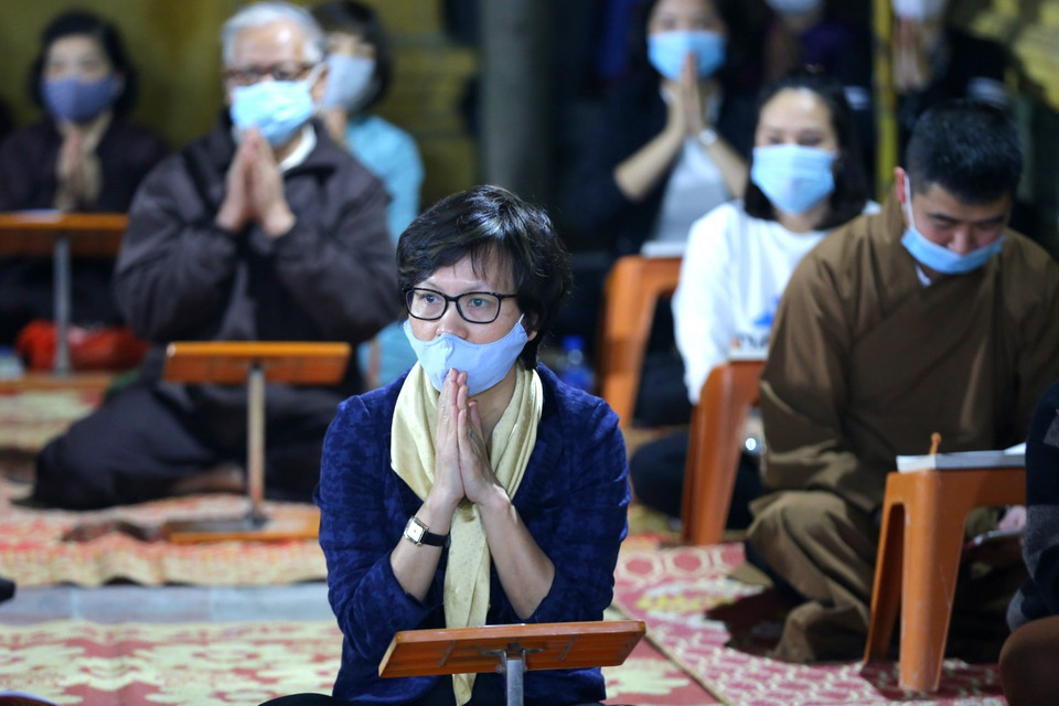 Các phật tử được vào bên trong làm lễ cầu an đều nghiêm túc đeo khẩu trang. (Ảnh: Thành Đạt/TTXVN)