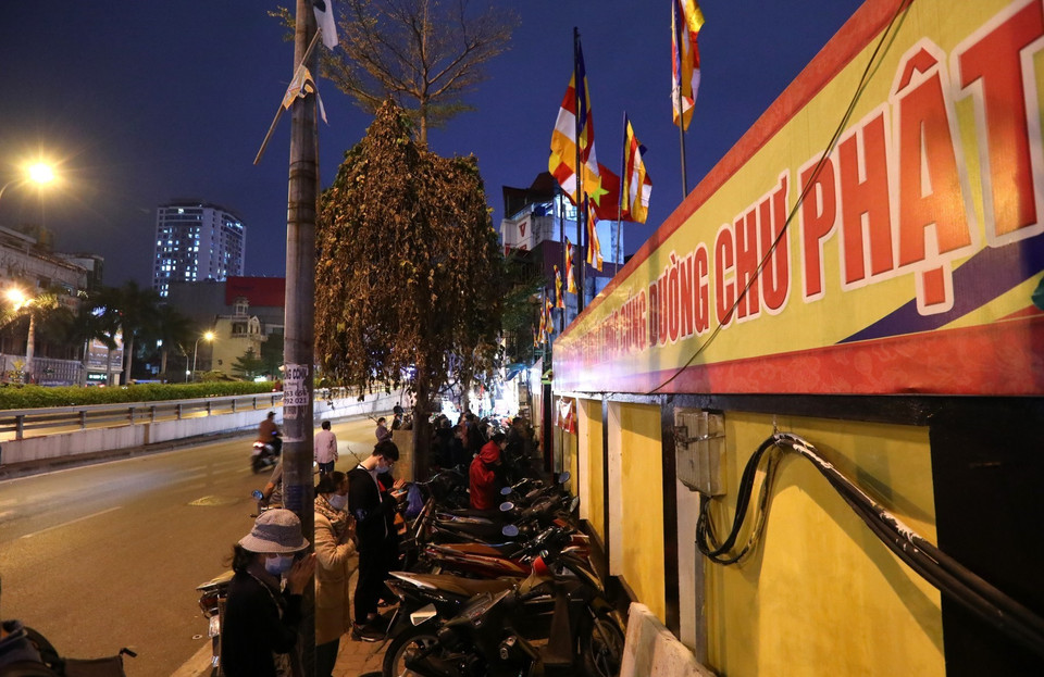 Lác đác vài người tìm đến chắp tay cầu an trước cửa chùa Phúc Khánh. (Ảnh: Thành Đạt/TTXVN)