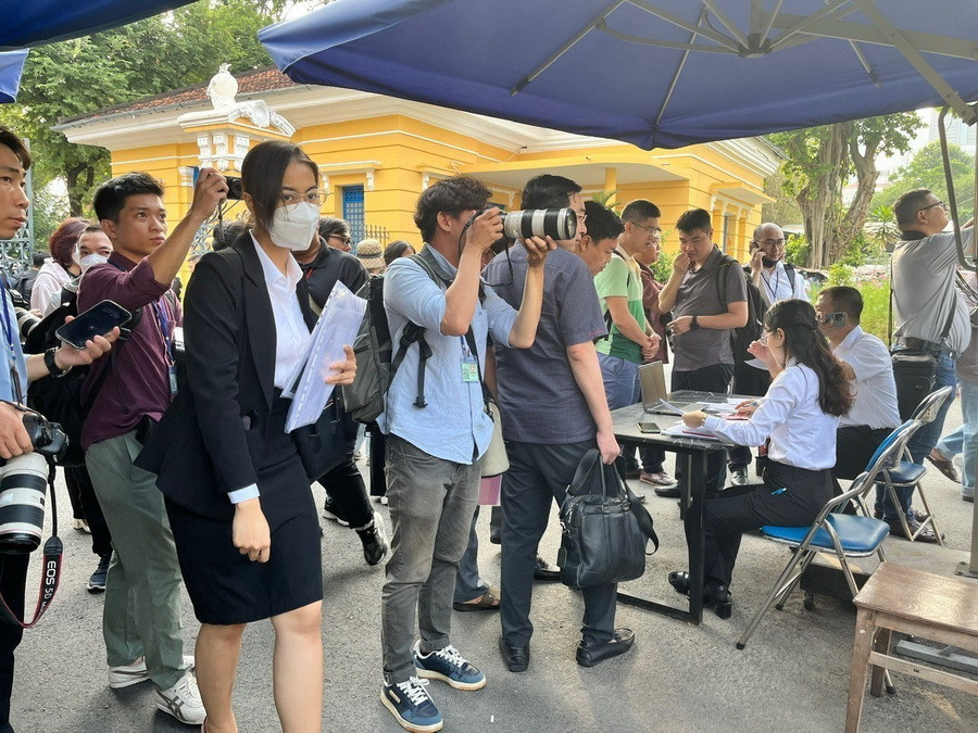 Luật sư, phóng viên báo chí, người được triệu tập được kiểm tra an ninh trước khi vào khu vực phiên tòa xét xử. (Ảnh: Thanh Vũ/TTXVN)